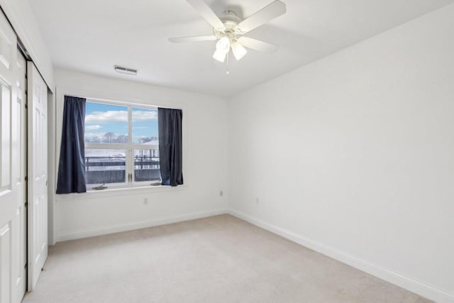 carpeted empty room featuring ceiling fan