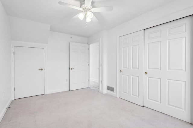 unfurnished bedroom with light colored carpet, a closet, and ceiling fan