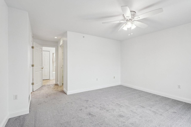 empty room featuring ceiling fan and light carpet