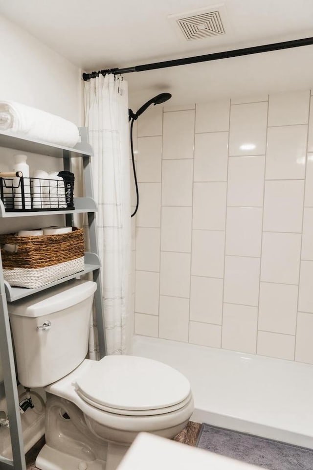 bathroom with a shower with curtain and toilet