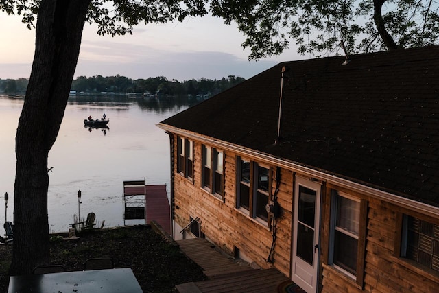 property exterior at dusk with a water view