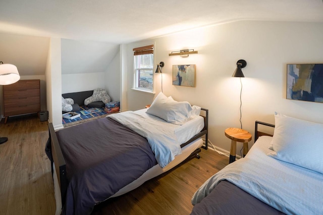 bedroom with vaulted ceiling and dark hardwood / wood-style floors