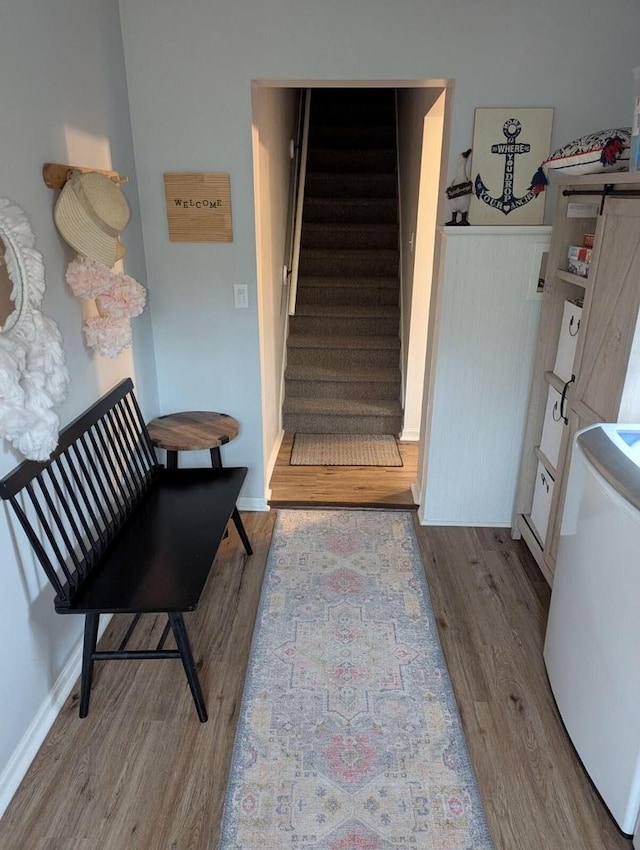 stairs featuring washer / dryer and wood-type flooring