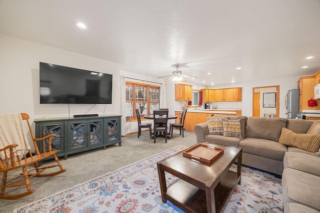 carpeted living room featuring ceiling fan