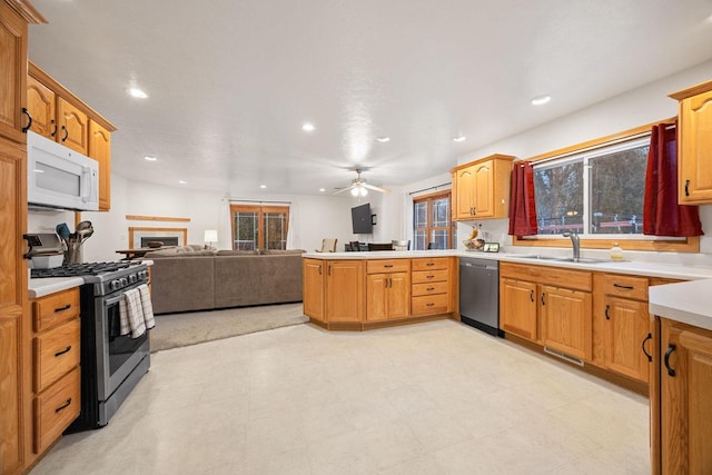 kitchen featuring ceiling fan, appliances with stainless steel finishes, kitchen peninsula, and sink