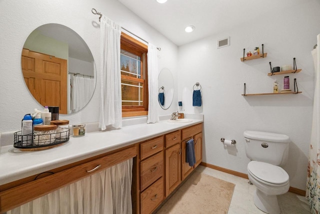 bathroom featuring vanity, toilet, and tile patterned flooring