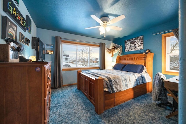 carpeted bedroom featuring ceiling fan, multiple windows, and a textured ceiling