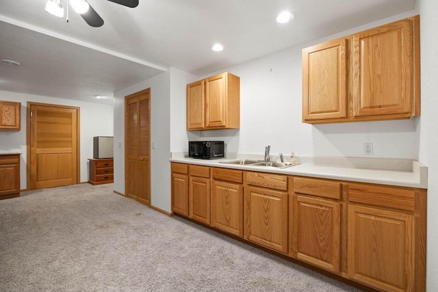 kitchen with ceiling fan, light colored carpet, and sink