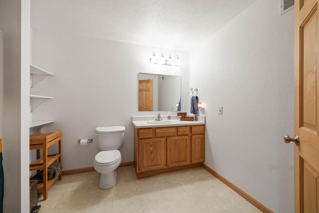 bathroom featuring vanity, a textured ceiling, and toilet