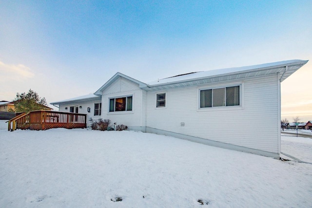 snow covered property with a deck