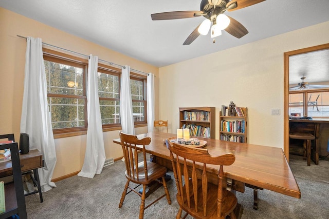 dining area featuring ceiling fan and carpet