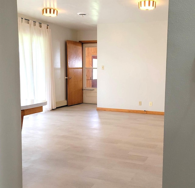 empty room featuring light wood-style flooring and baseboards