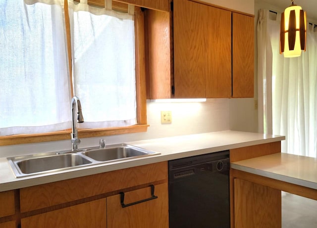 kitchen with brown cabinetry, light countertops, dishwasher, and a sink