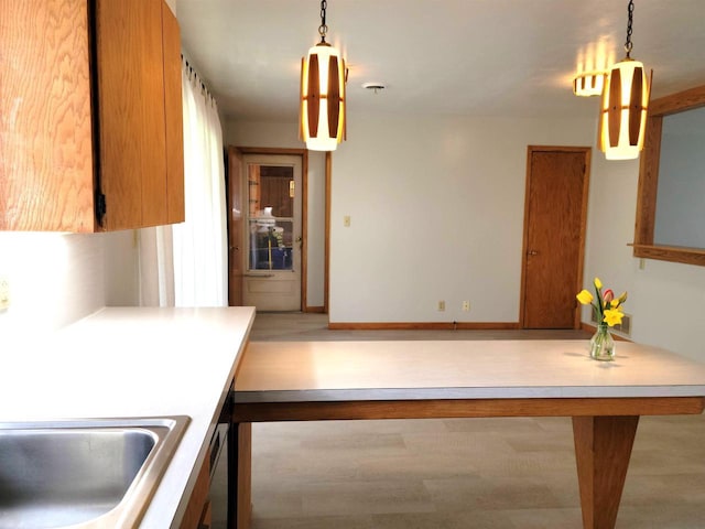 kitchen with decorative light fixtures, baseboards, and wood finished floors