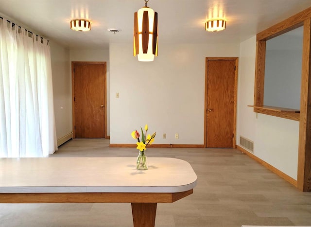 hallway with a baseboard radiator, light wood-style floors, baseboards, and visible vents