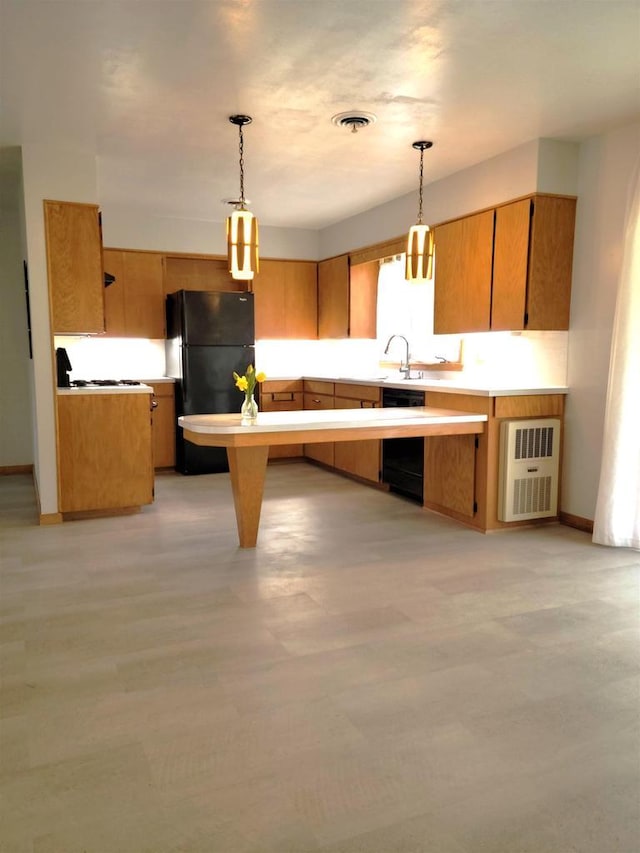 kitchen with a sink, visible vents, light countertops, black appliances, and decorative light fixtures