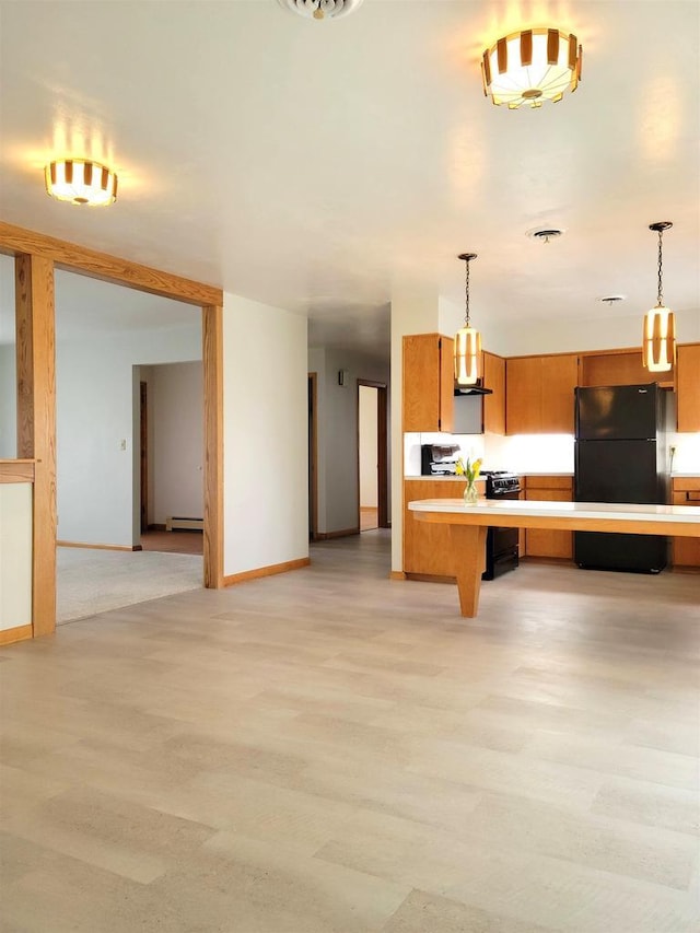 kitchen with black appliances, a breakfast bar area, light countertops, and light wood-style floors