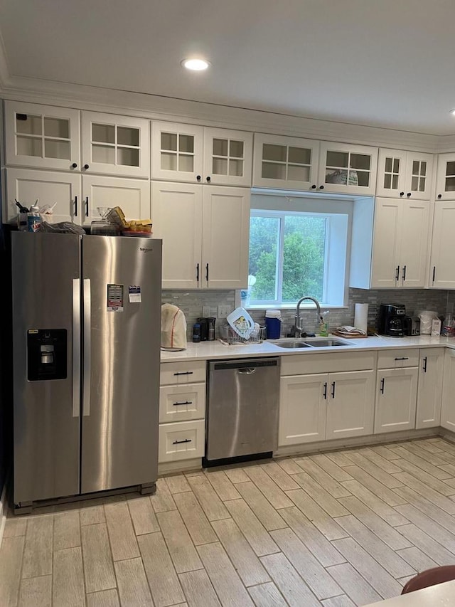 kitchen with white cabinetry, appliances with stainless steel finishes, sink, and light hardwood / wood-style floors