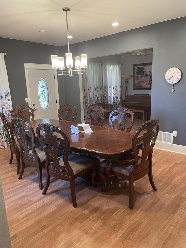 dining room featuring a notable chandelier and light wood-type flooring