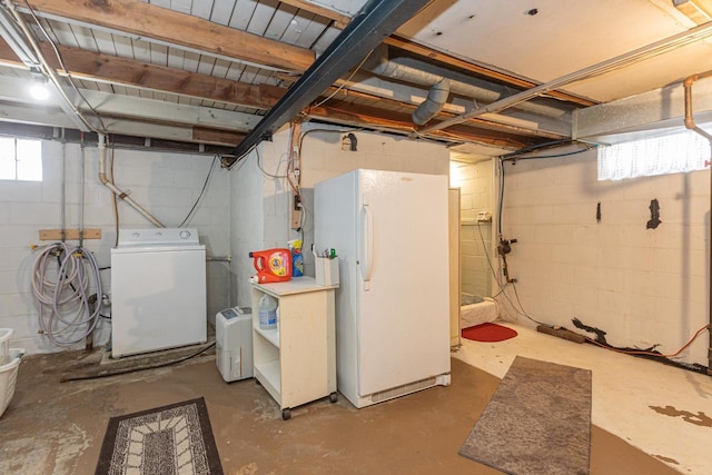 basement featuring white refrigerator and independent washer and dryer