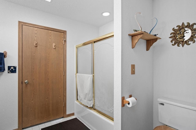 bathroom with enclosed tub / shower combo and toilet