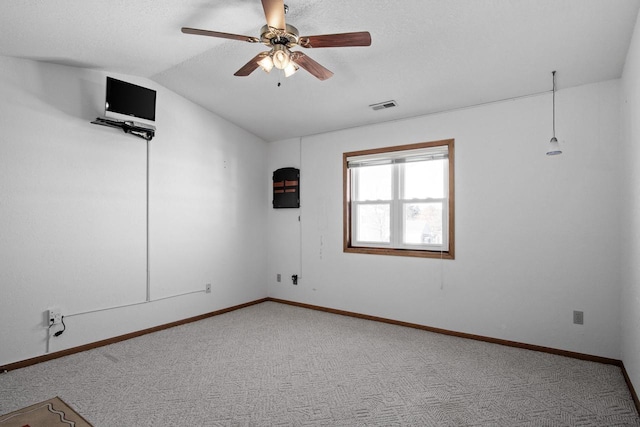 spare room featuring lofted ceiling, carpet floors, and ceiling fan