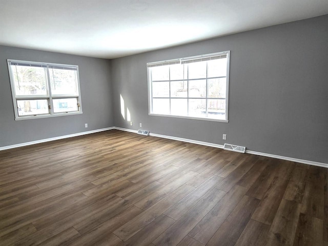 unfurnished room with dark wood-type flooring