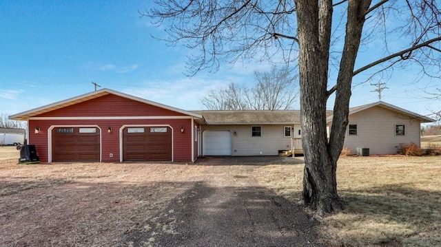 ranch-style house featuring a garage and central AC