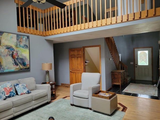 living room with wood-type flooring and a towering ceiling