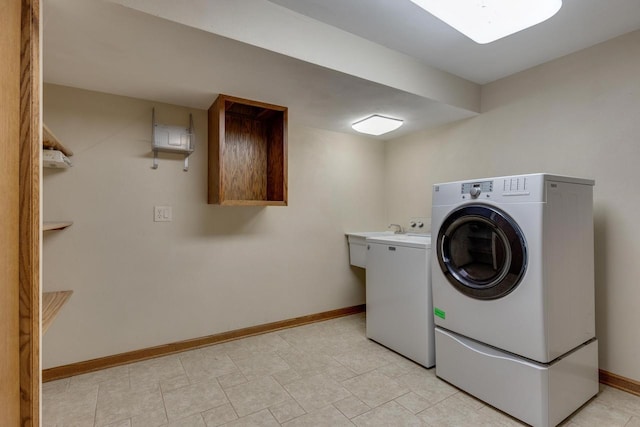 laundry room featuring sink, washer and clothes dryer, and cabinets