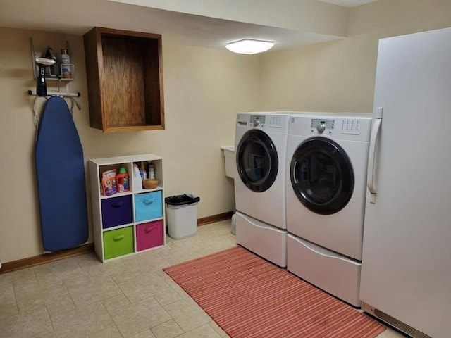 washroom with cabinets and washing machine and clothes dryer