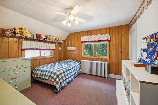 carpeted bedroom featuring lofted ceiling, radiator, ceiling fan, and wood walls