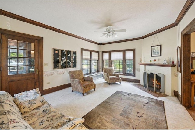 carpeted living room featuring ornamental molding, ceiling fan, and a textured ceiling