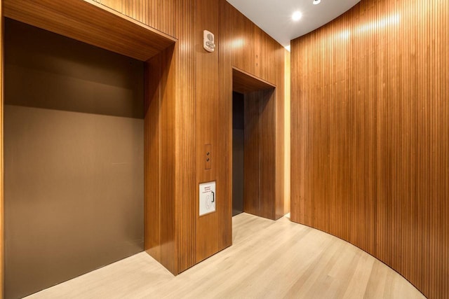 hall featuring hardwood / wood-style flooring and wood walls