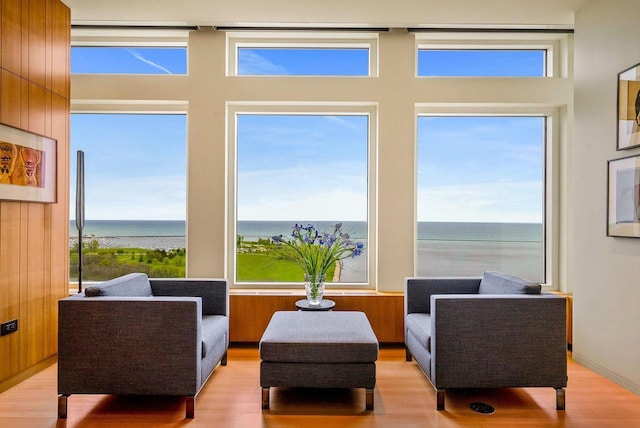 living area with a water view and light hardwood / wood-style flooring