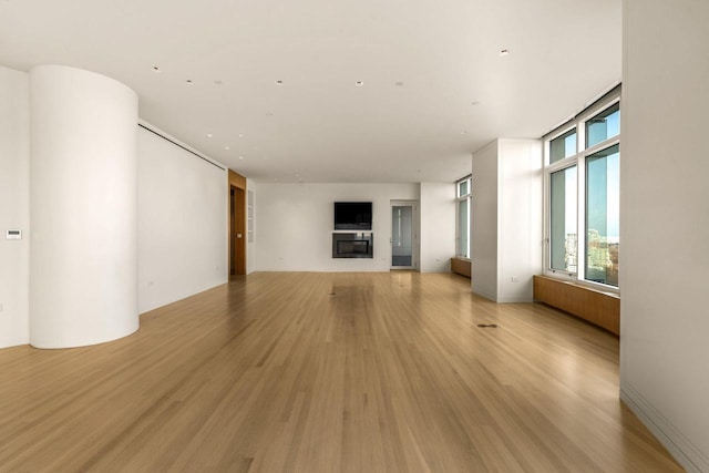 unfurnished living room with floor to ceiling windows and light hardwood / wood-style flooring