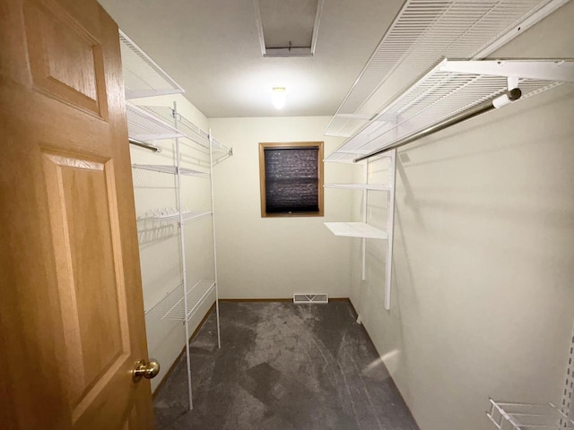 walk in closet featuring dark carpet