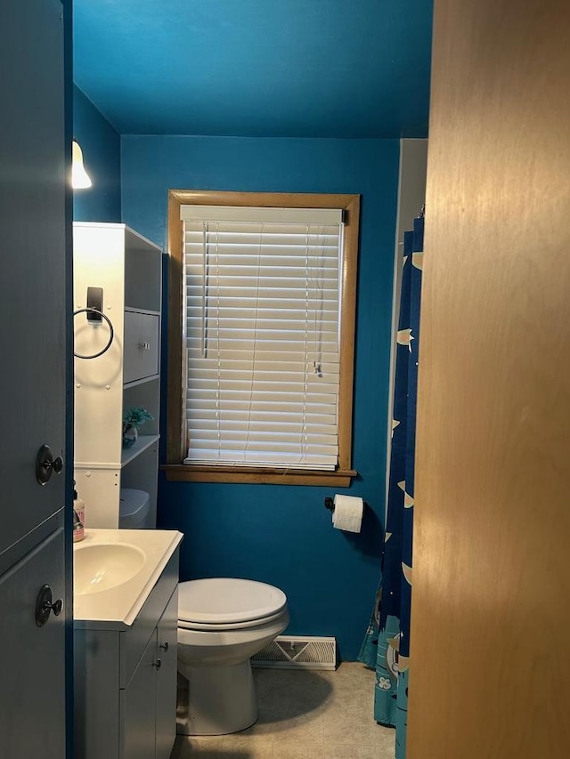 bathroom with tile patterned flooring, vanity, and toilet