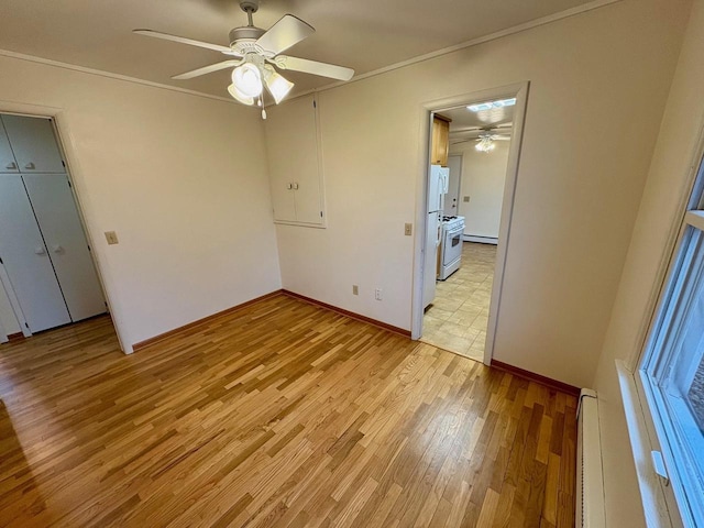 unfurnished bedroom featuring white refrigerator, a baseboard heating unit, ceiling fan, light hardwood / wood-style floors, and crown molding