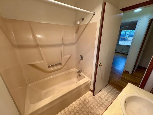 bathroom with sink, shower / bathtub combination, and baseboard heating