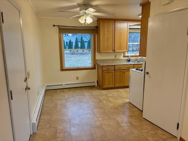 kitchen featuring white gas range, sink, ceiling fan, and baseboard heating