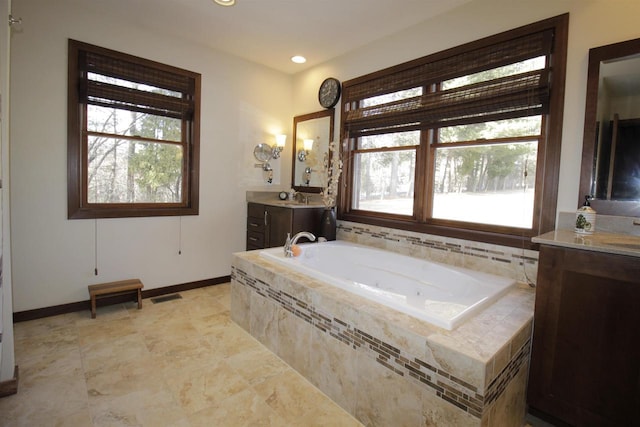 bathroom with vanity and a relaxing tiled tub