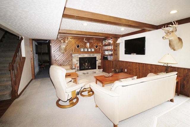 living room featuring a fireplace, beam ceiling, and a textured ceiling