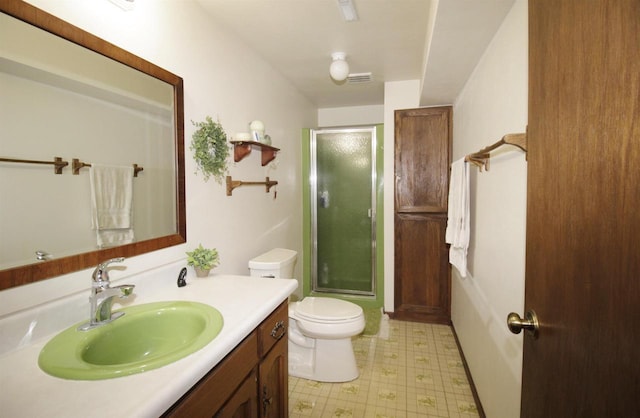 bathroom featuring vanity, toilet, and a shower with shower door