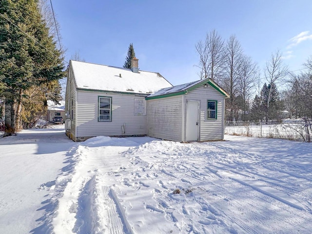 snow covered property featuring an outdoor structure