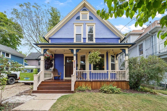 victorian-style house with a front yard and covered porch