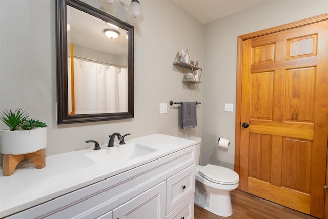 bathroom featuring vanity, hardwood / wood-style floors, and toilet