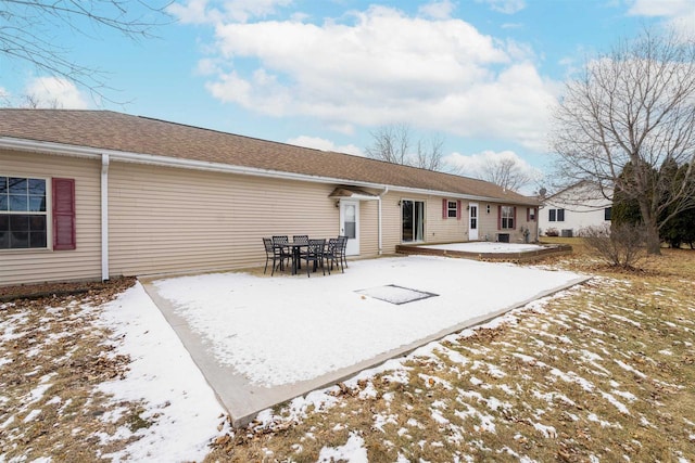 snow covered house featuring a patio area