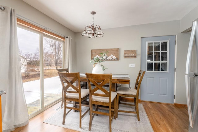 dining area featuring light hardwood / wood-style floors and a chandelier