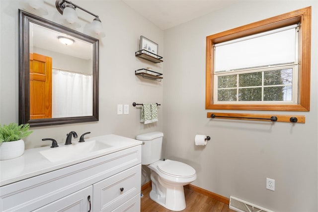 bathroom with vanity, toilet, and hardwood / wood-style floors